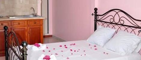 Un dormitorio con una cama, un aparador de madera y un baño visible a través de una puerta abierta.