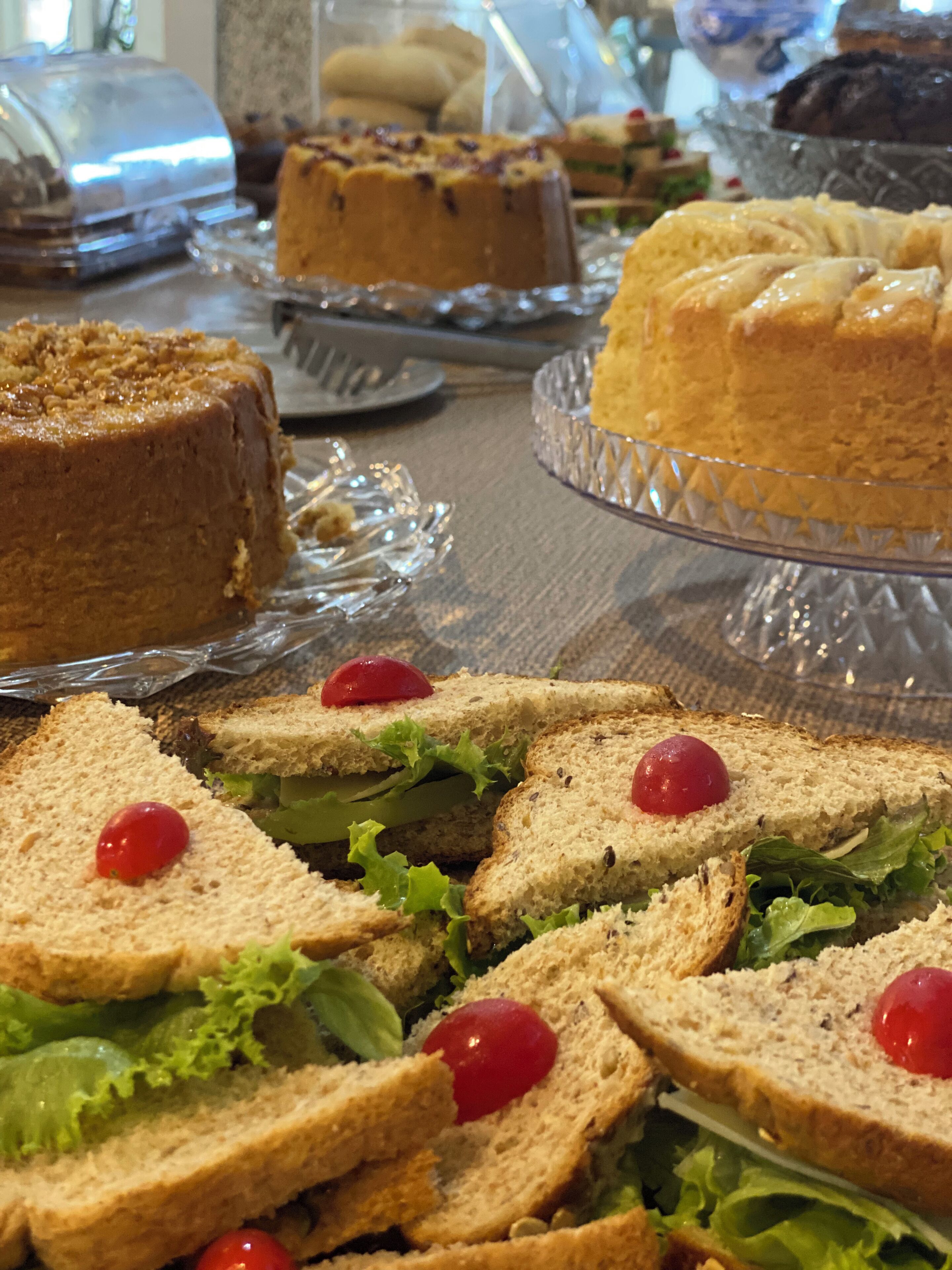 Una mesa con sándwiches y pasteles.