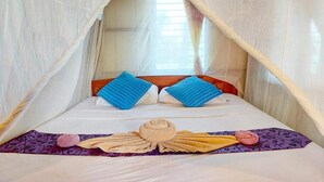 A bed with a canopy, pillows, and a decorative towel arrangement. - Jungle Hill Beach Bungalow (Nuea Khlong)