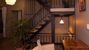 A staircase with a black railing, a wooden table, and a hanging light fixture.