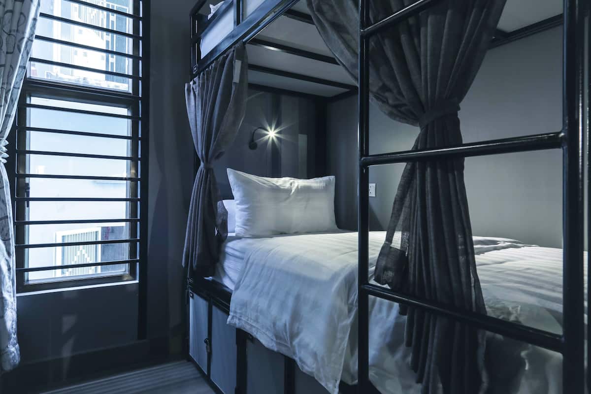 Quarto com beliche, janela, cortinas e luminária em formato de estrela.