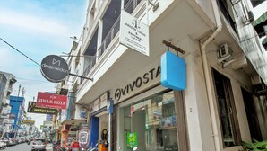 A street view with a building labeled "VIVOSTA" and various other shops. - Vivo Stay (Medan)