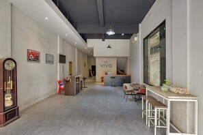 Un interior moderno con una recepción, zona de estar y un ventanal grande.