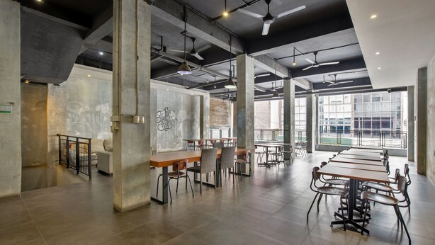 A spacious, modern conference room with high ceilings, exposed beams, and large windows. - Vivo Stay (Medan)