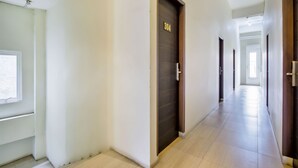 A long, narrow hallway with a wooden door labeled "304" and a window on the left. - Vivo Stay (Medan)