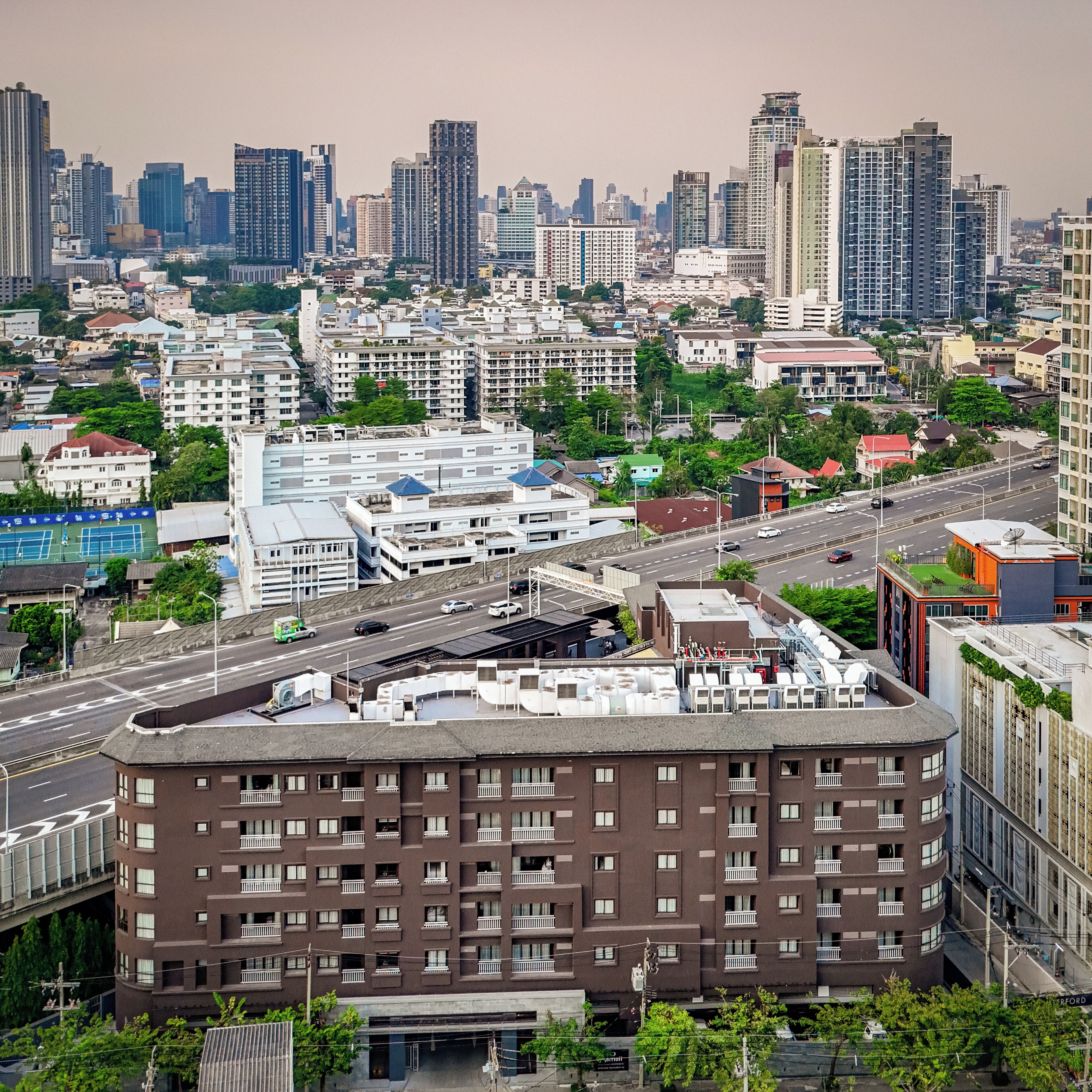 A high-rise building with multiple floors, large windows, and balconies.