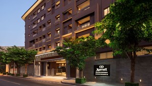 A modern hotel with multiple balconies, a well-lit entrance, and a sign indicating it is the Marriott Executive Apartments in Bangkok Sukhumvit 50. - Marriott Executive Apartments Bangkok, Sukhumvit 50 (Bangkok)