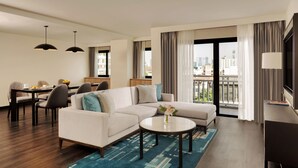 A modern hotel room with a living area, dining space, and a balcony with a city view. - Marriott Executive Apartments Bangkok, Sukhumvit 50 (Bangkok)
