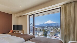 A hotel room with two beds, a TV, and a large window offering a view of a mountain. - HOTEL MYSTAYS Fuji Onsen Resort (Fujiyoshida)