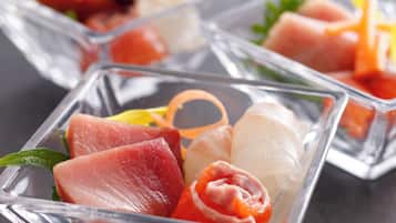 A glass dish with various types of sashimi.