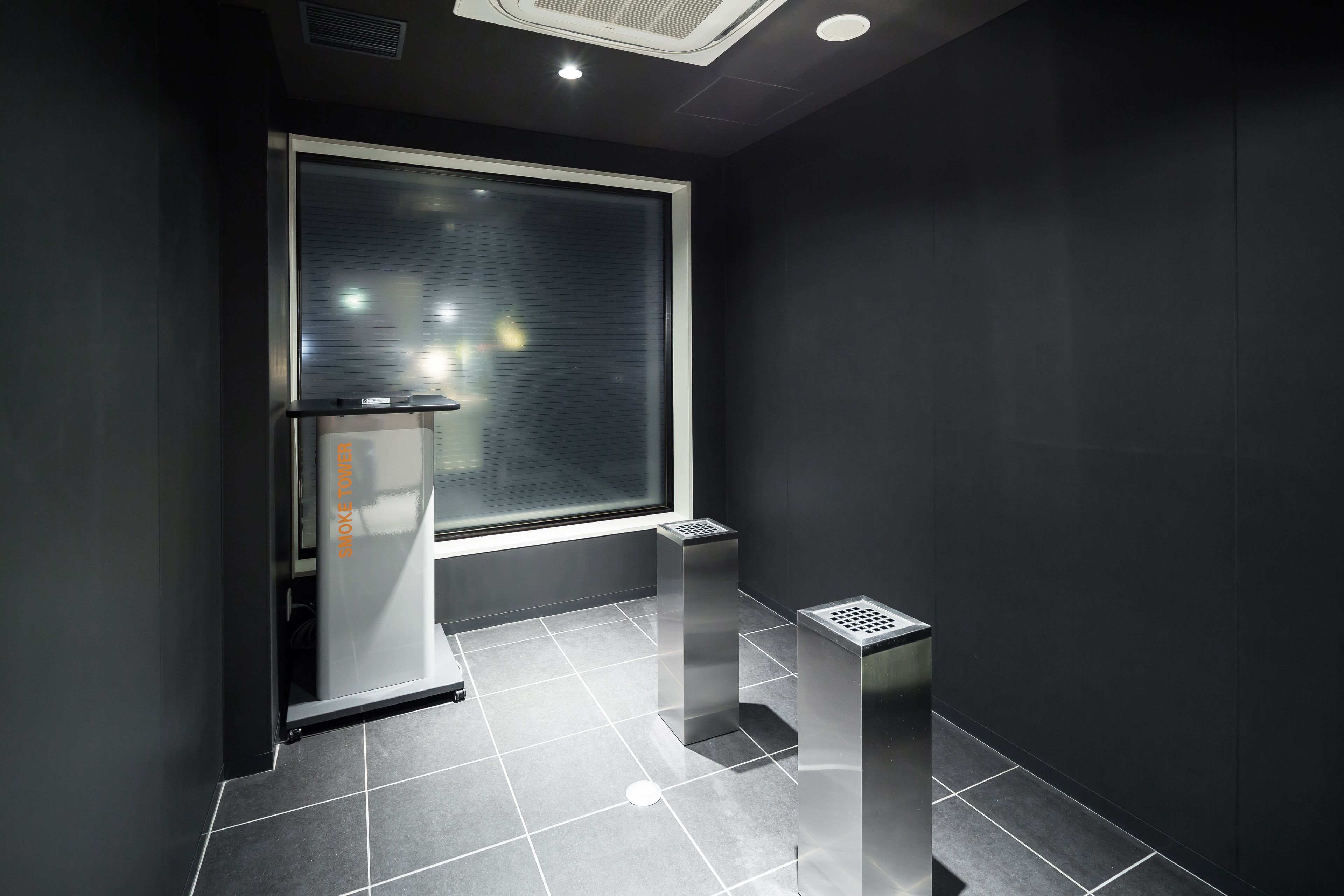 A modern bathroom with a large window, a toilet, and a sink.