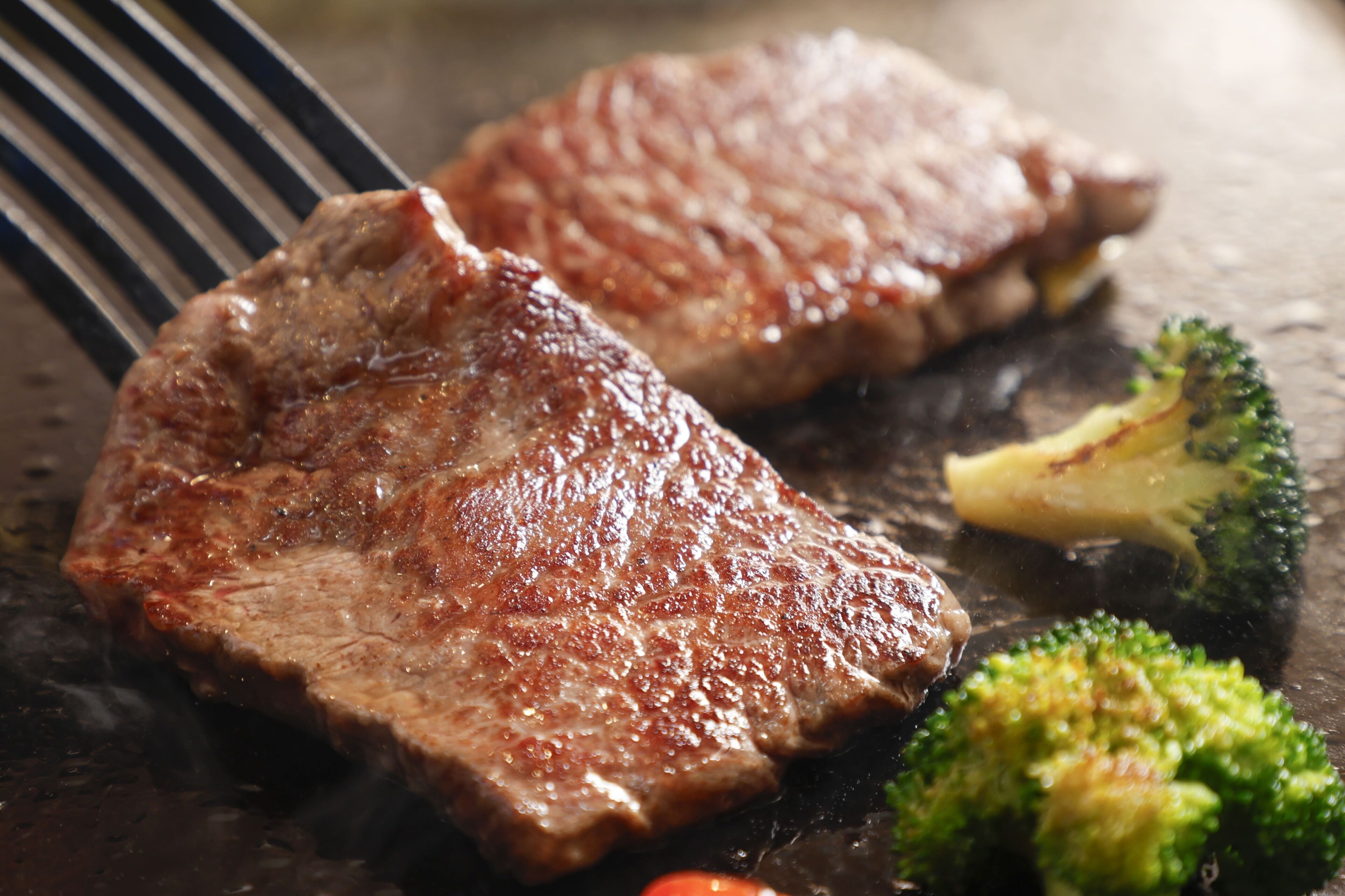 A steak and broccoli on a grill.