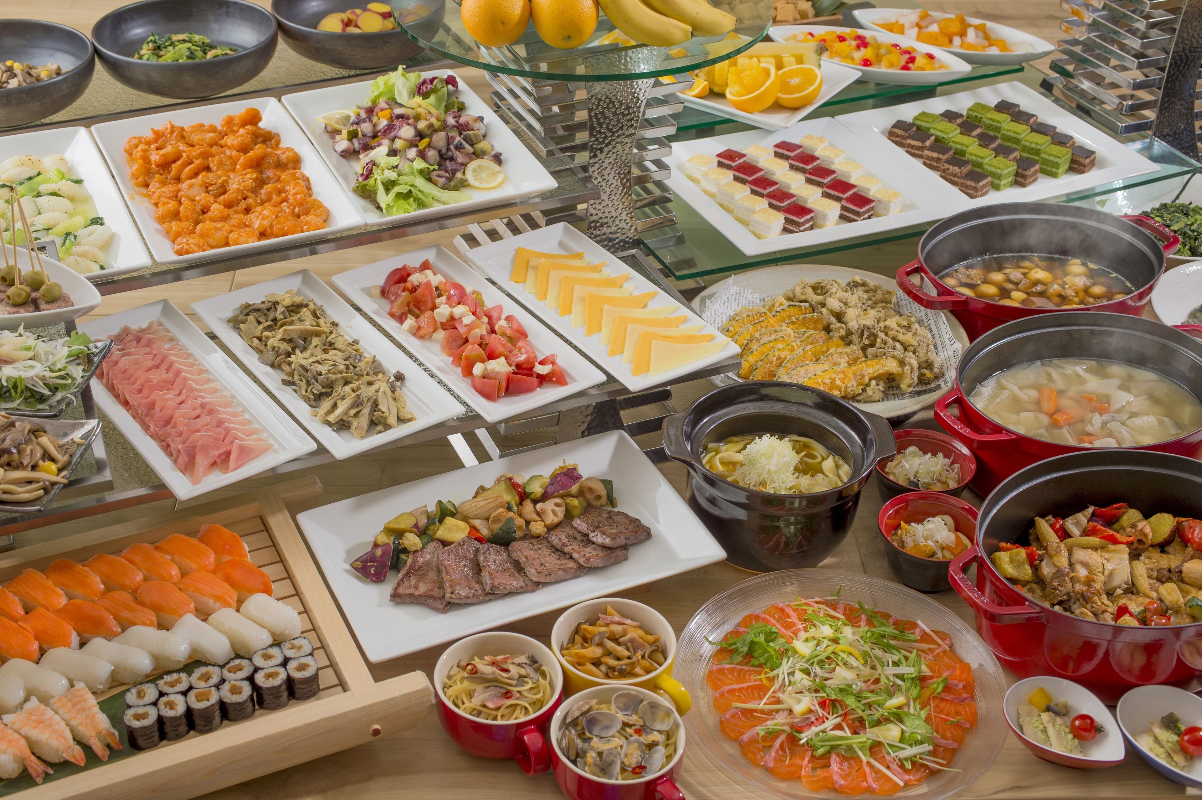 A buffet with various dishes including sushi, meats, and vegetables.