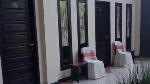 A hotel lobby with a reception desk, a seating area with chairs, and a tiled floor. - Jaya Phita Guest House (Kupang)