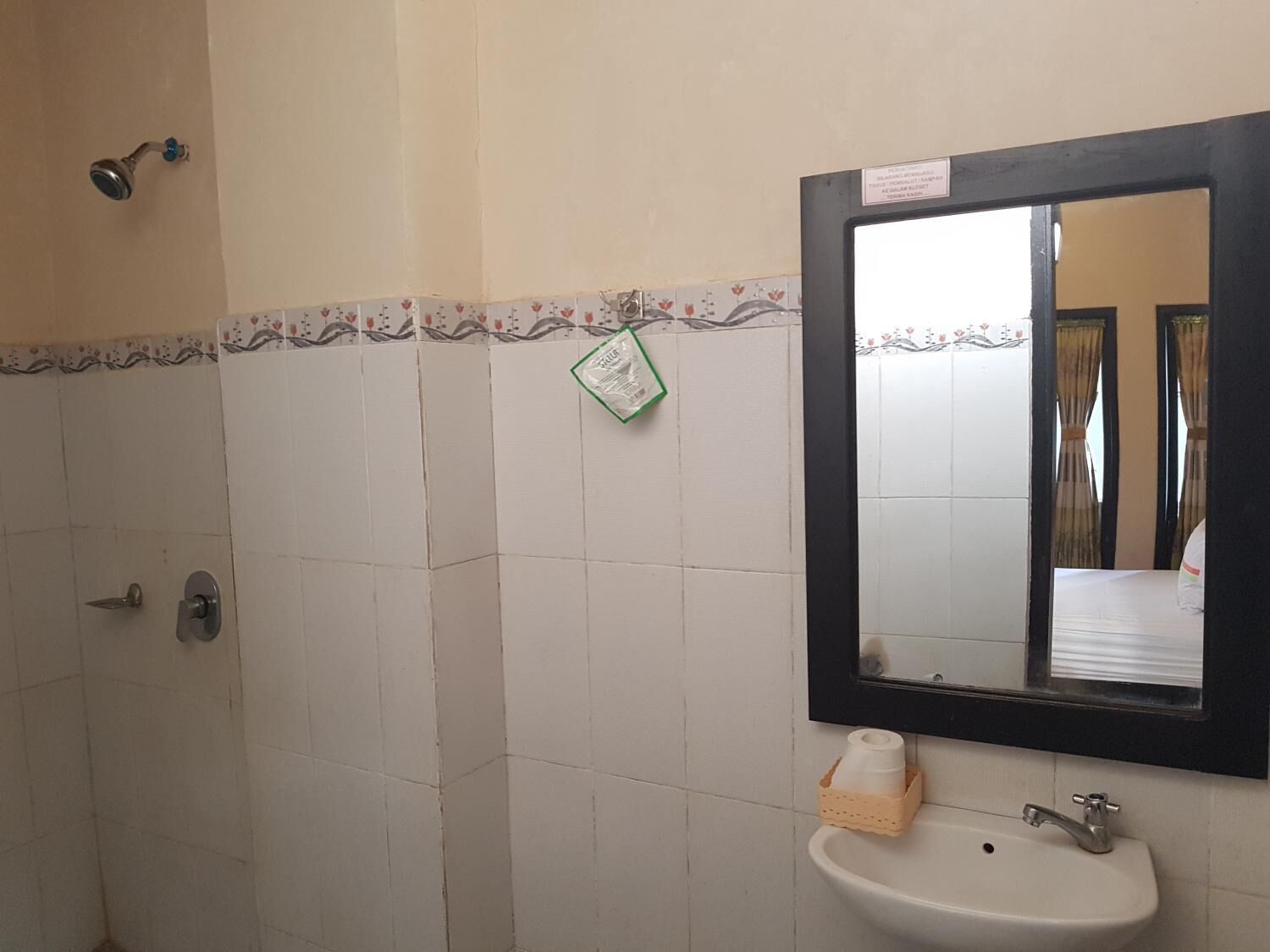 A bathroom with a white sink, a mirror, and a shower.