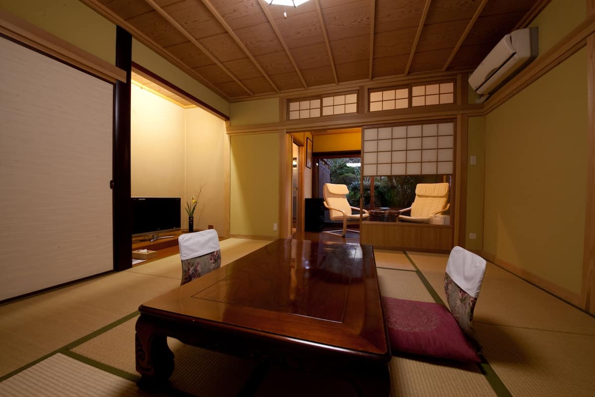 A traditional Japanese room with tatami flooring, a low wooden table, and shoji screens.