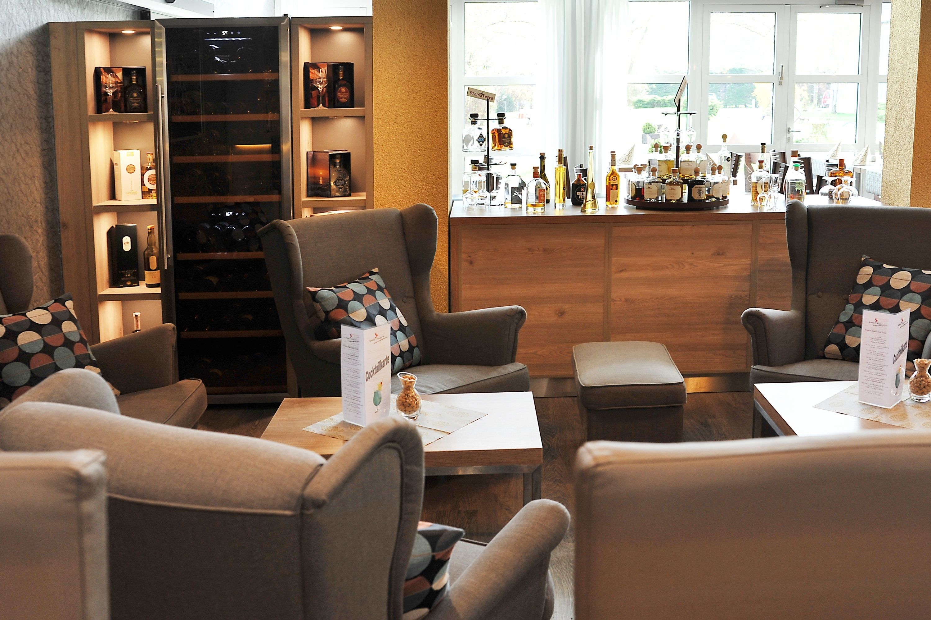 A bar area with seating and a wine cooler.