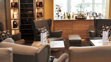 A bar area with seating and a wine cooler.