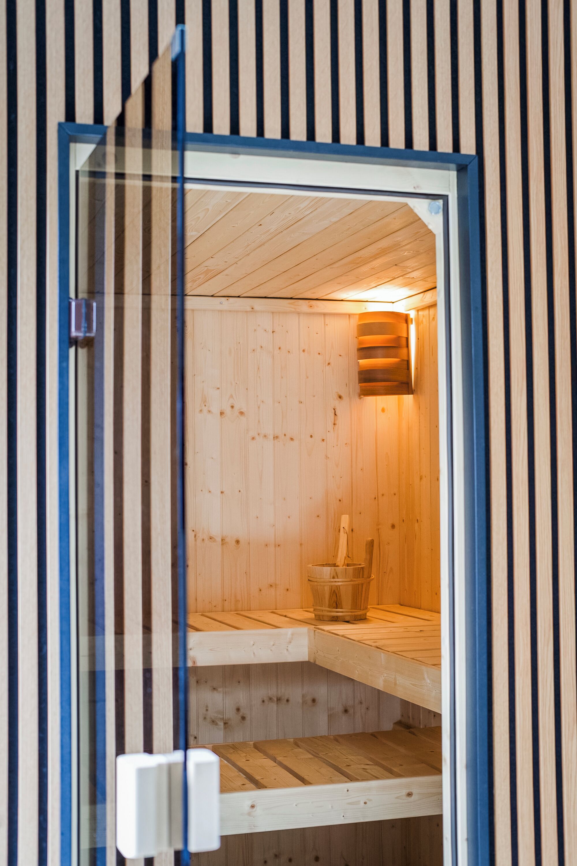 Una sauna con interior de madera y entrada enmarcada en azul.