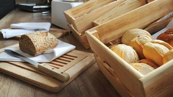 A wooden cutting board with a knife and a loaf of bread on it.