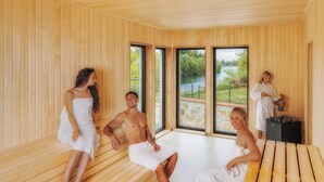 A sauna room with wooden benches and large windows. - Bernstein Acamed Resort (Nienburg)