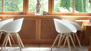 Interior de madera con dos sillas blancas y una encimera de madera.