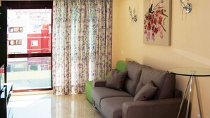 A living room with a brown sofa, a glass coffee table, and a painting on the wall. - La Volpe Rossa (Las Palmas de Gran Canaria)