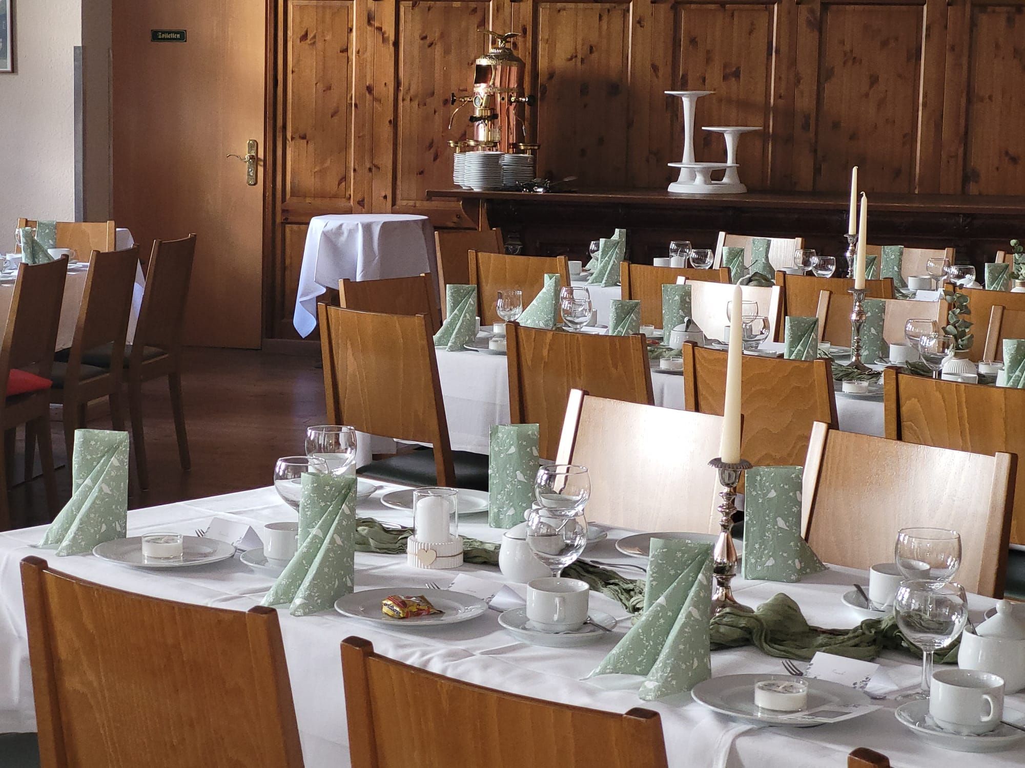 Un restaurante con varias mesas dispuestas para comer, cada una con platos, vasos y cubiertos.