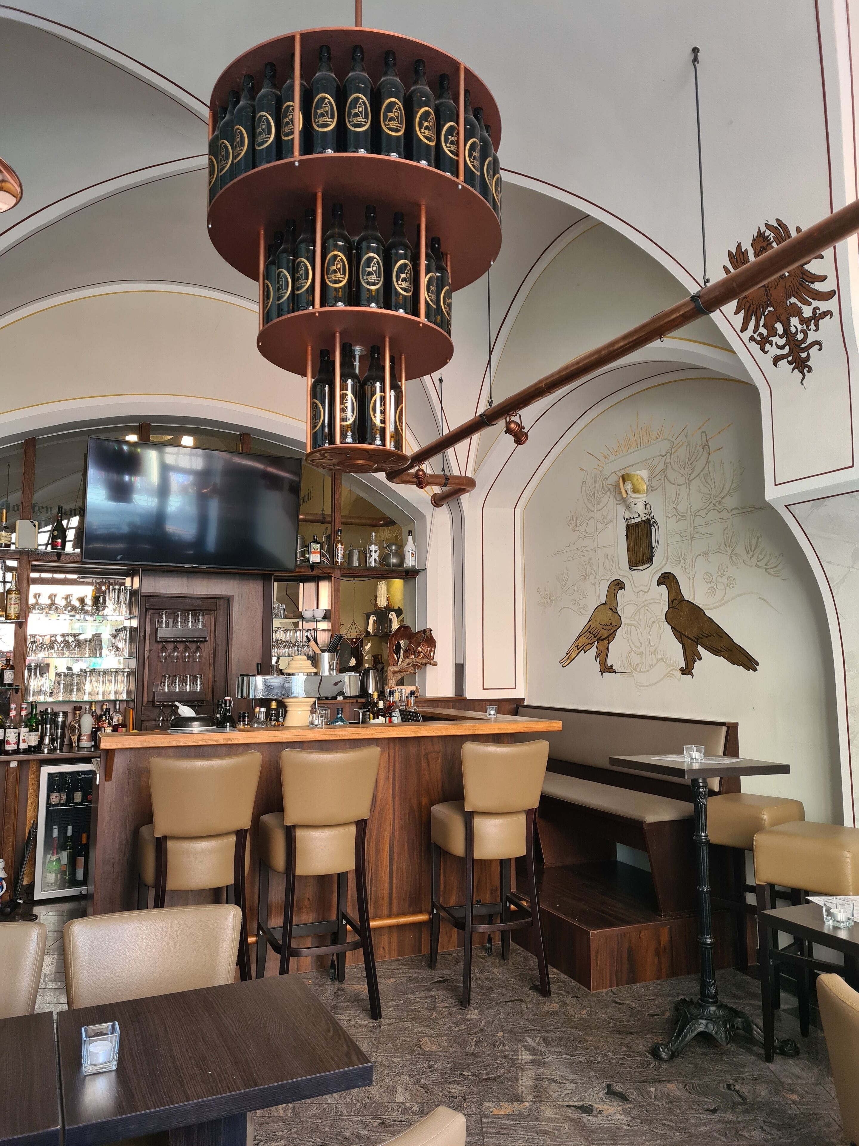 Eine Bar mit Weinkühler, Tresen und Sitzgelegenheiten.
