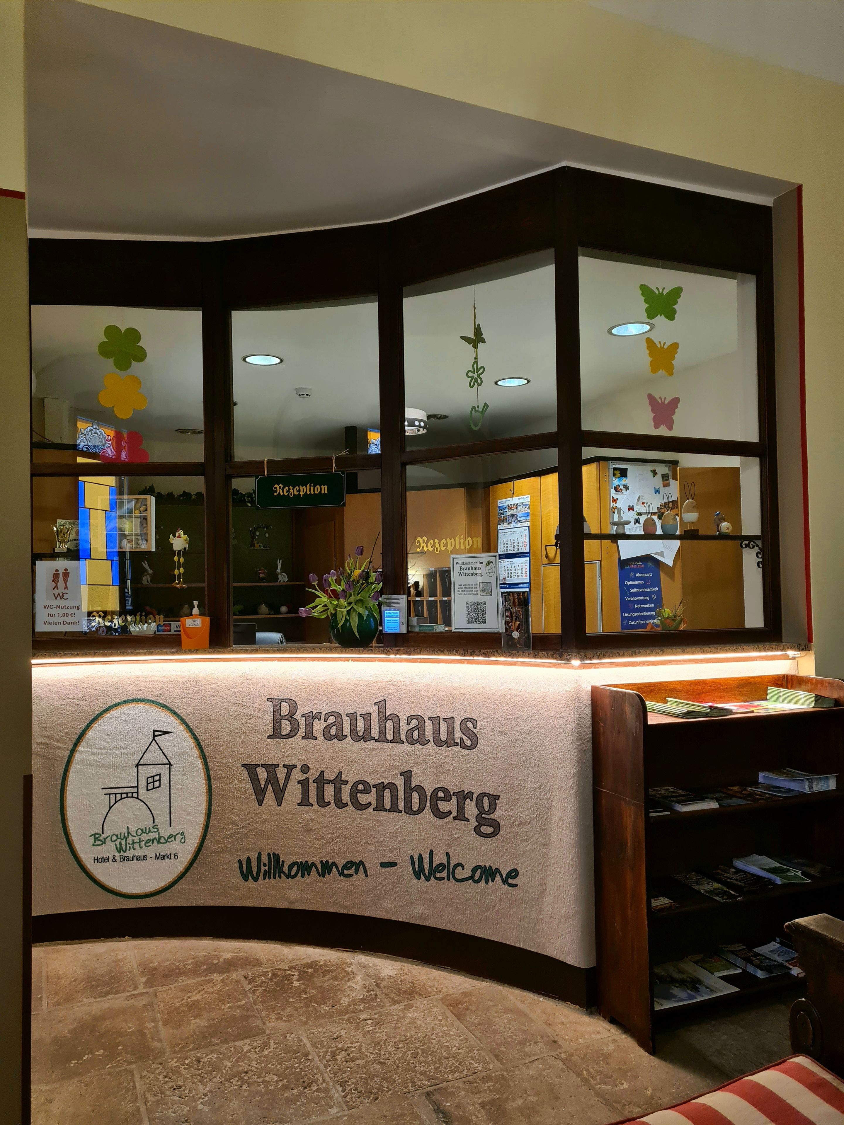 Una recepción con un cartel que dice 'Brauhaus Wittenberg' y 'Bienvenidos'.