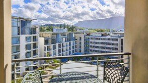 En balkon med udsigt til moderne bygninger og et bjerg i baggrunden.