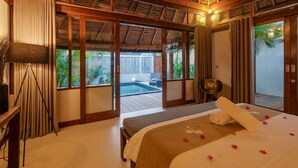 Un dormitorio con una cama grande, vistas a una piscina y techo de madera.