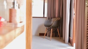 Una habitación moderna con una mesa de comedor, una silla y un ventanal con cortinas.