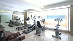 A gym with treadmills, elliptical machines, and weight benches. - Cubic Bed Pratunam - Hostel (Bangkok)