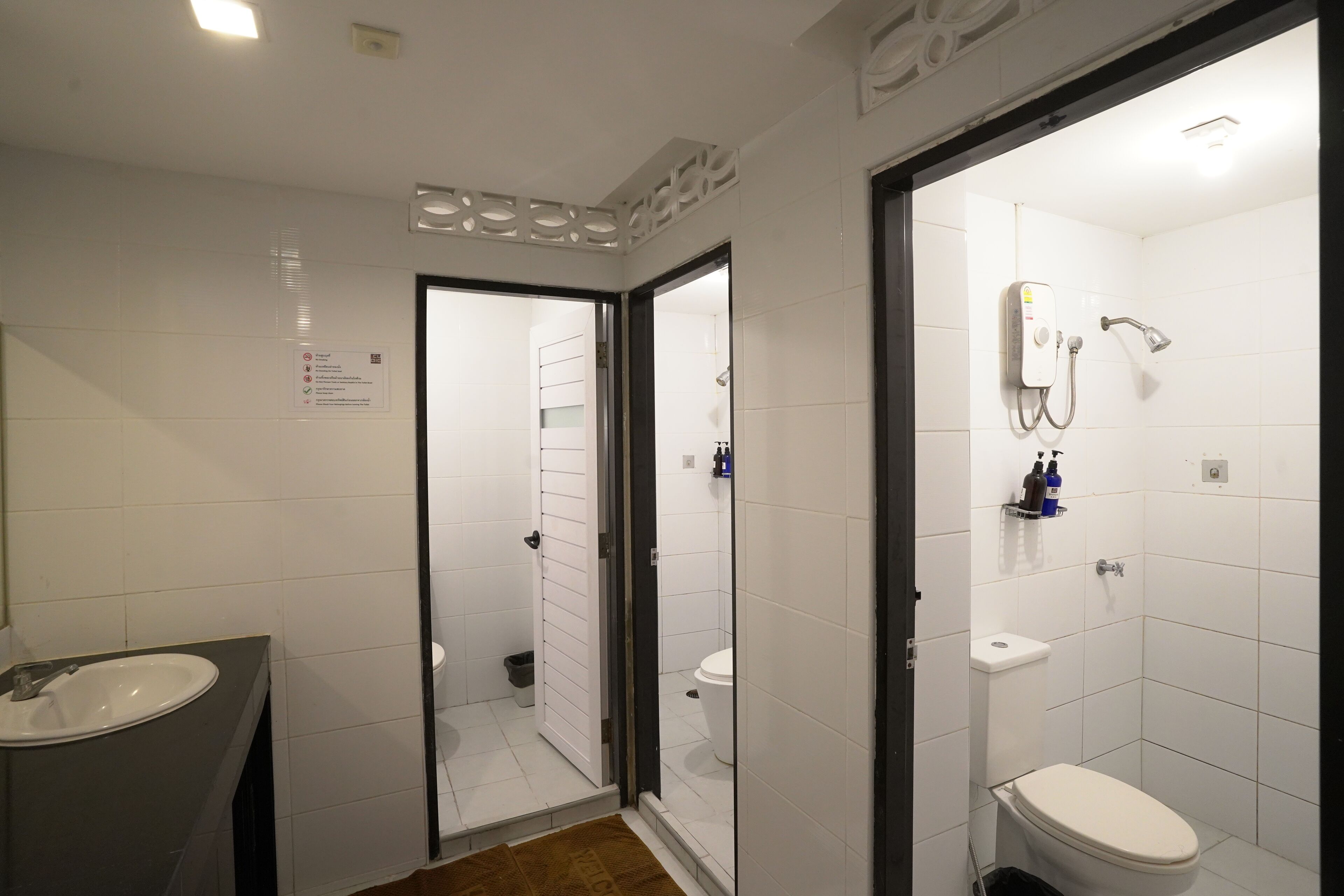 A modern bathroom with a sink, toilet, and shower area.