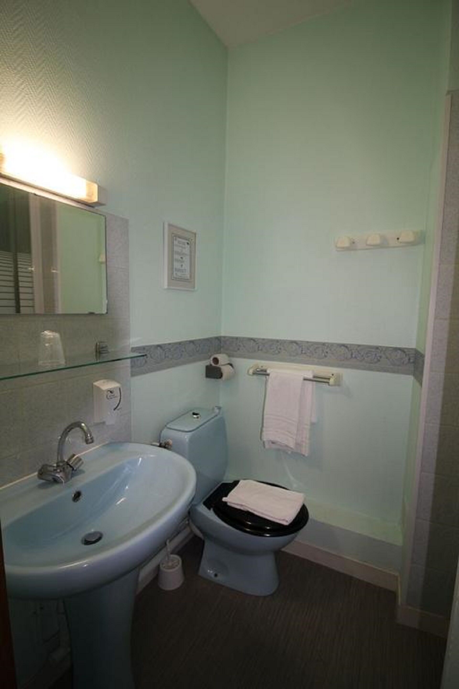 A bathroom with a sink, toilet, and shower area.