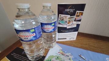 Two bottles of Cristaline water, a brochure for Contact Hotels, and a map of France.