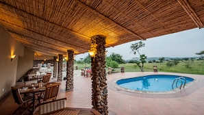 Una piscina al aire libre, sombrillas, tumbonas