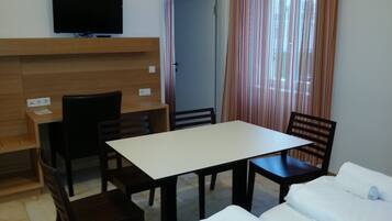 Ein Zimmer mit einem Bett, einem Schreibtisch und einem Fernseher.