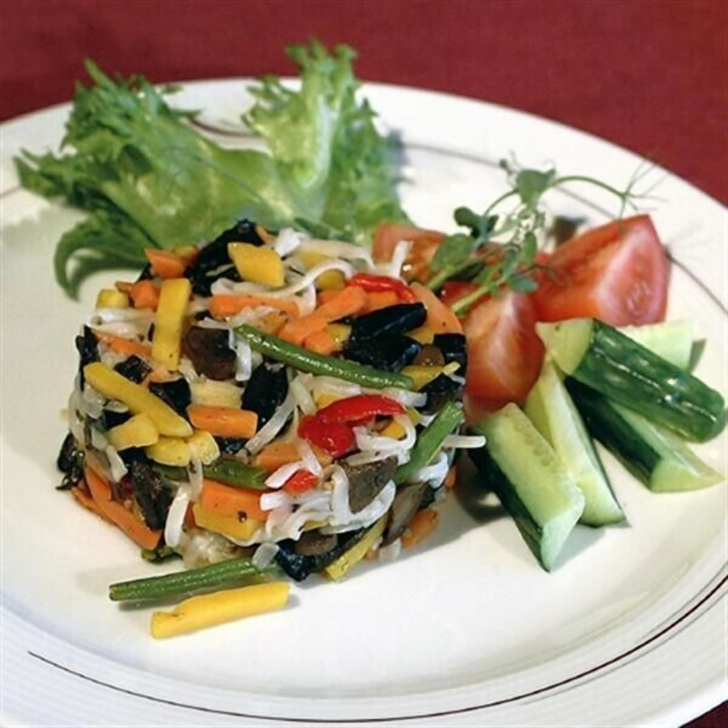 A plate with a vegetable salad, including lettuce, tomatoes, cucumbers, and various other vegetables.