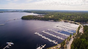 An aerial view of a marina with docks and boats, surrounded by forested land. - Imatra Spa Sport Camp - Hostel (Imatra)