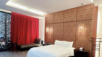 Una habitación de hotel con una cama, un escritorio, una silla y una cortina roja.