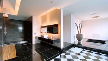 Um banheiro moderno com piso quadriculado em preto e branco, um espelho grande e um lavatório de madeira.