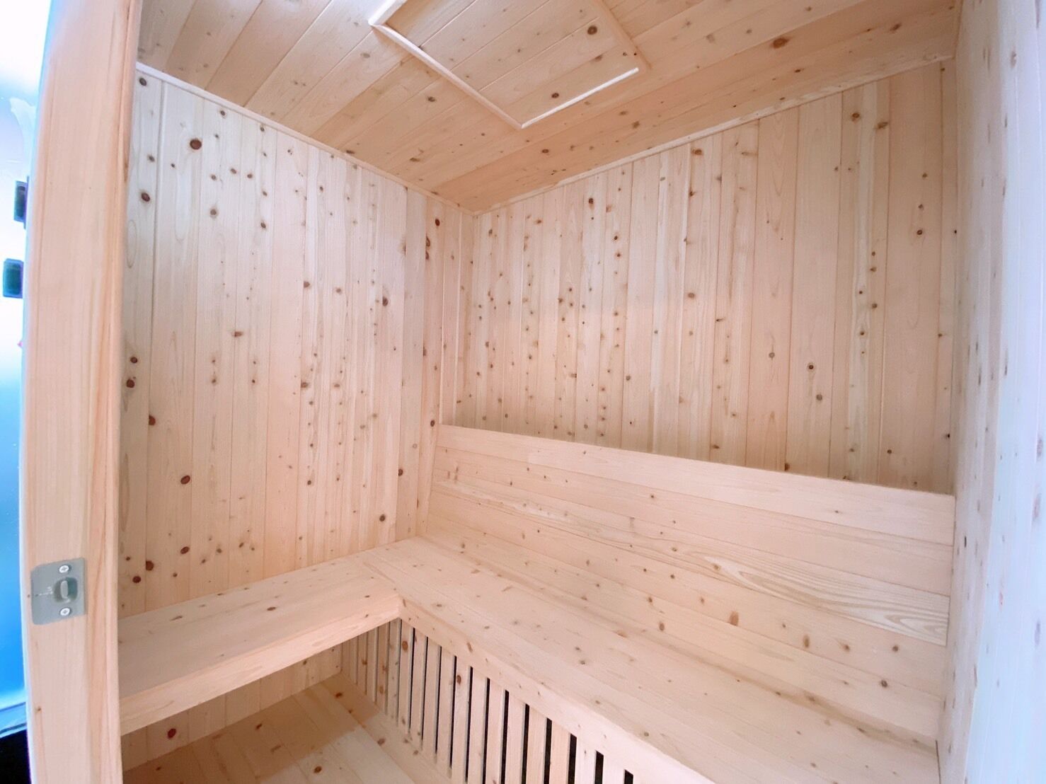 Una sauna de madera con techo inclinado y bancos integrados.