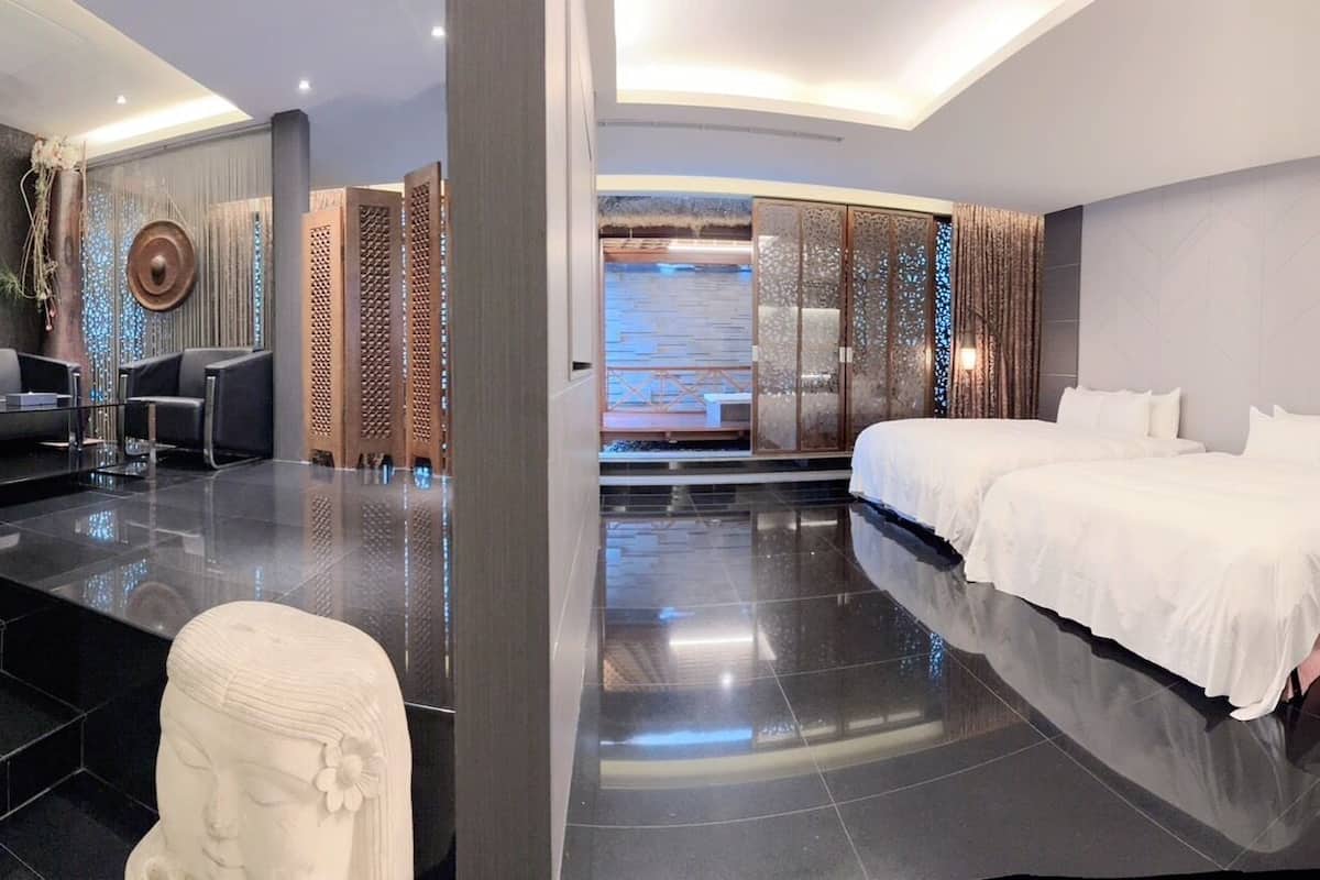 Quarto de hotel moderno com uma cama grande, uma mesa e uma área de estar.