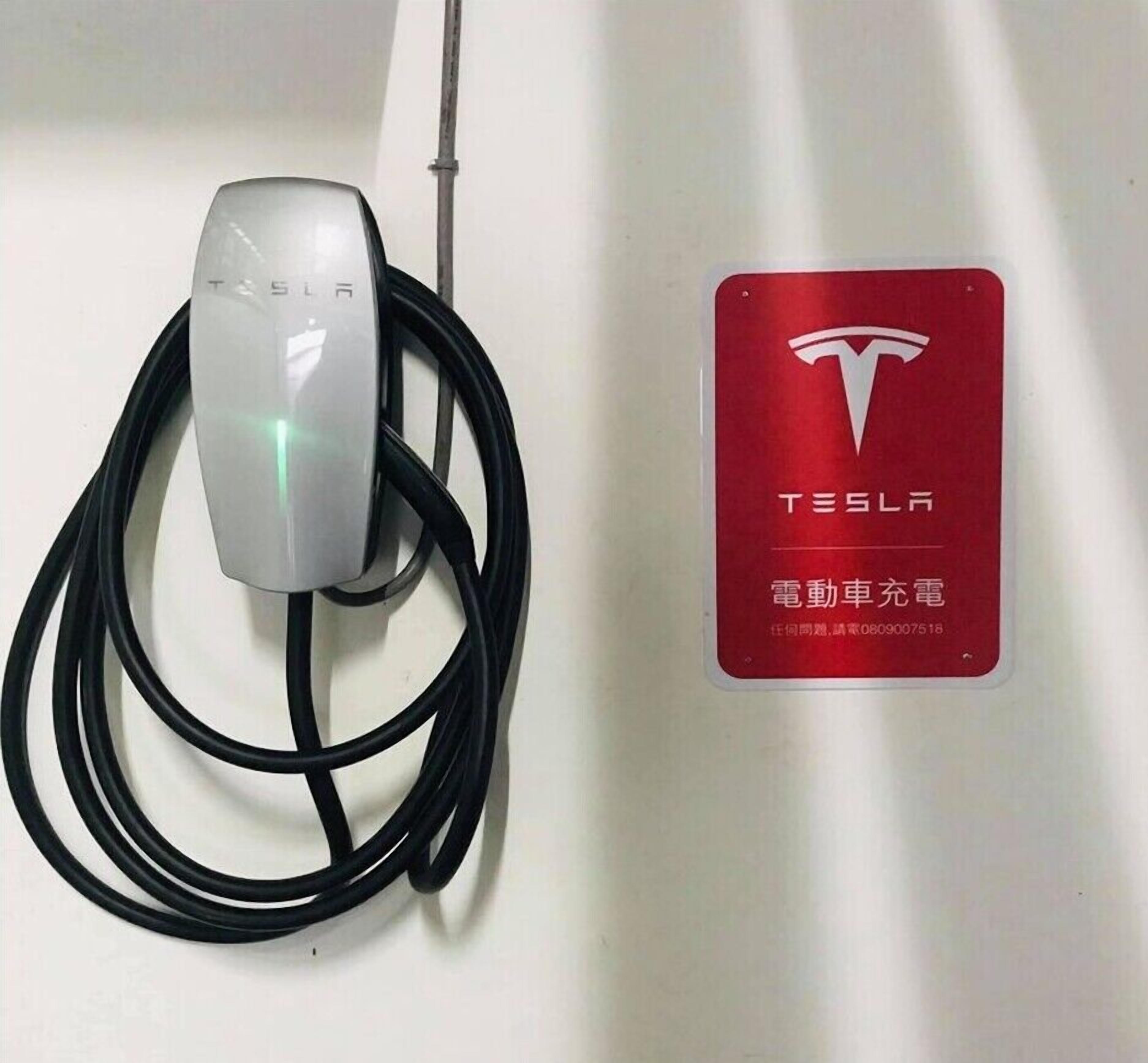 Una estación de carga Tesla con un letrero del logotipo Tesla en rojo.