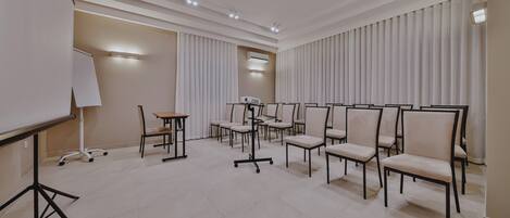A conference room with a whiteboard, a projector, and several chairs arranged for a meeting.