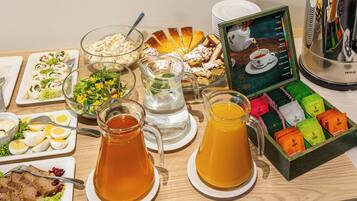 Un buffet de petit-déjeuner proposant divers plats, boissons et un assortiment de thés.