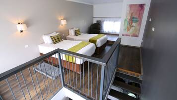 A hotel room with two beds, a staircase, and a large abstract painting on the wall.