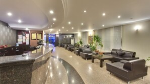 A modern lobby with a reception desk, seating area, and a blue-lit entrance. - Hotel Antroyal (Antalya)